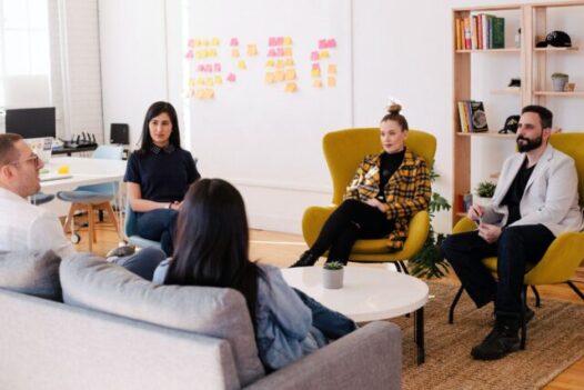 People meet in a meeting and sit on armchairs