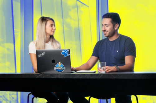 Two Happy Employees at a Desk with a Laptop